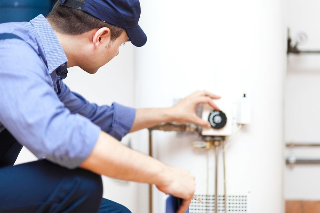 plumber doing maintenance on a water heater