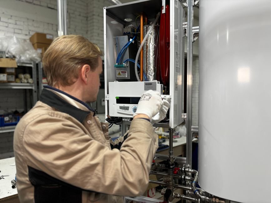 image of a plumber wearing white safety gloves opening a gas hot water heater for a service for a tankless hot water heater