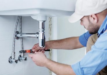 plumber repairing the bathroom sink plumbing in an Illinois home