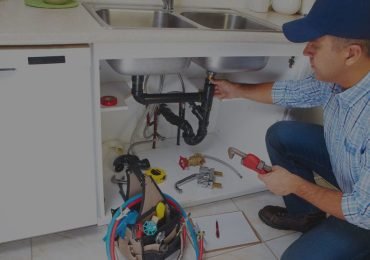 plumber repairing the kitchen sink plumbing in an Illinois home