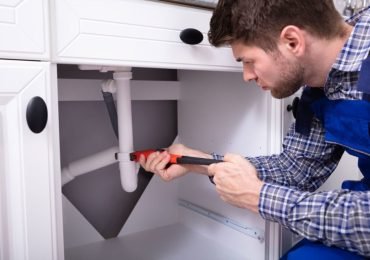 plumber repairing the sink plumbing in a residential property